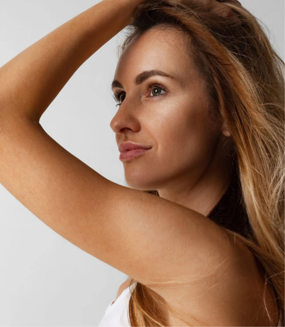 Woman in profile with arm raised displaying arm contour