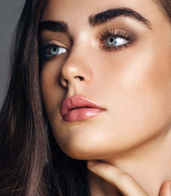 Woman's face with lifted, arched eyebrows and defined brow position
