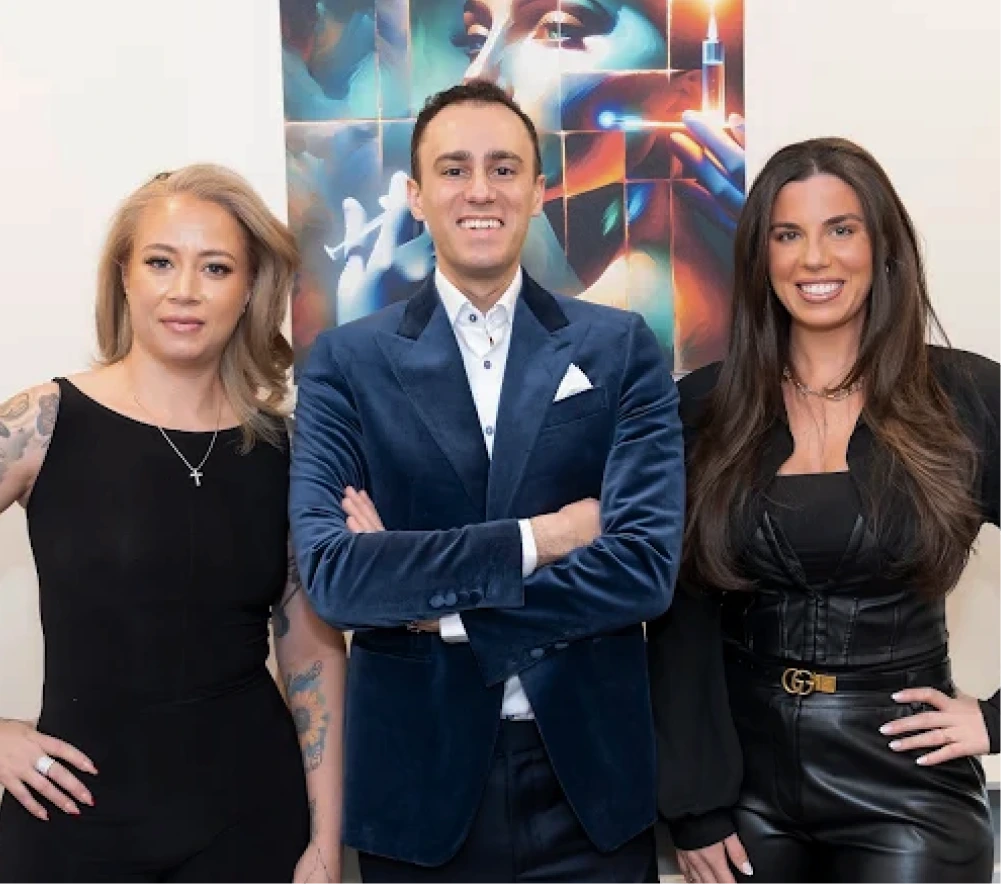 Three professionals standing together in front of colorful abstract backdrop