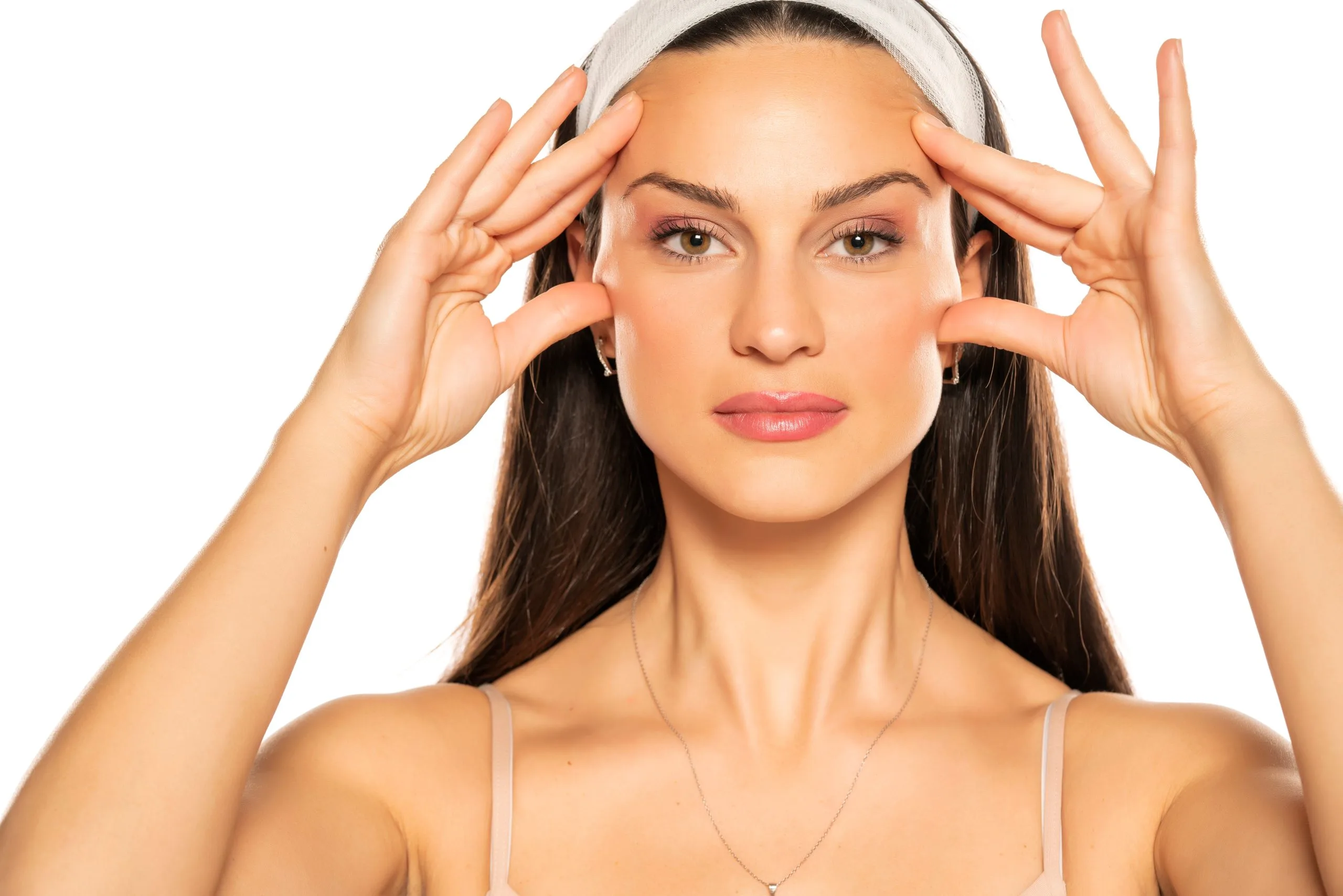 Woman wearing headband touching her forehead and temples with both hands