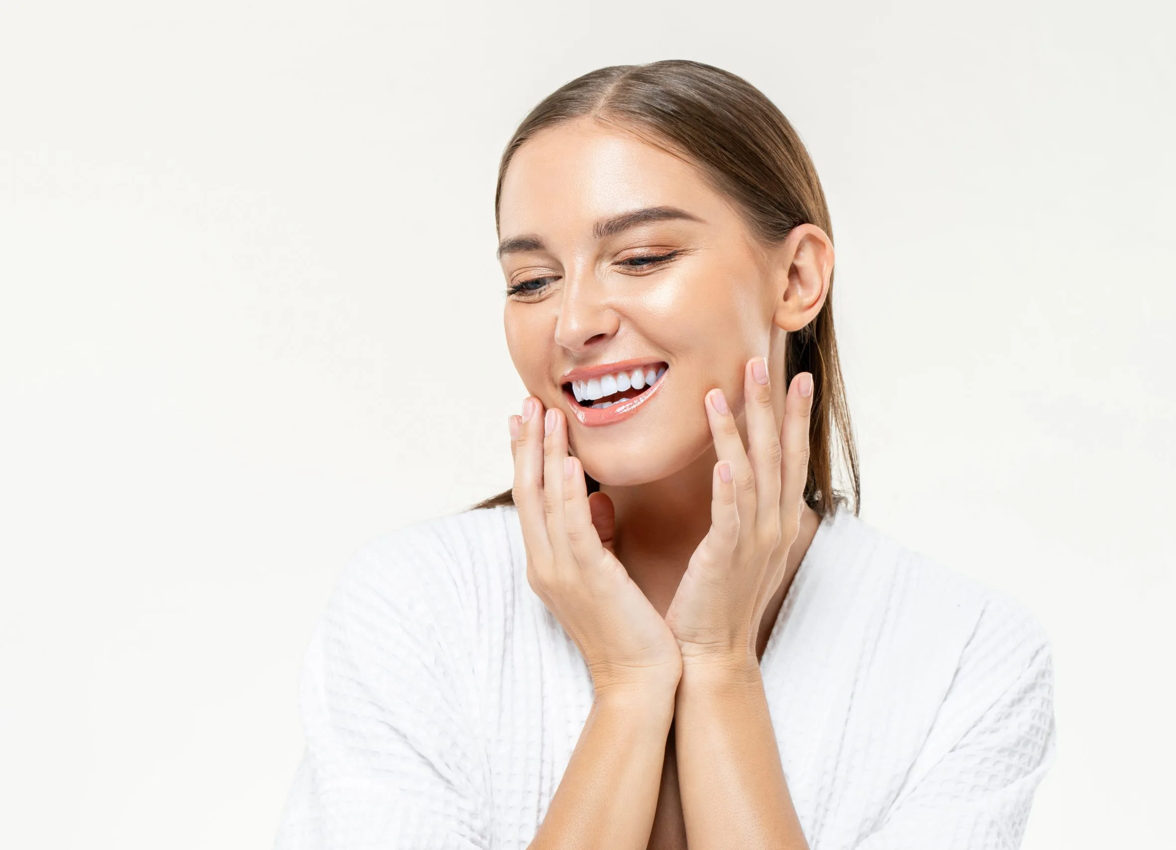 Woman smiling with hands framing her face showing bright teeth