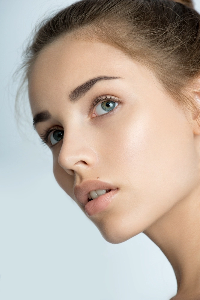 Woman's profile showing defined cheekbones, smooth skin, and blue-green eyes
