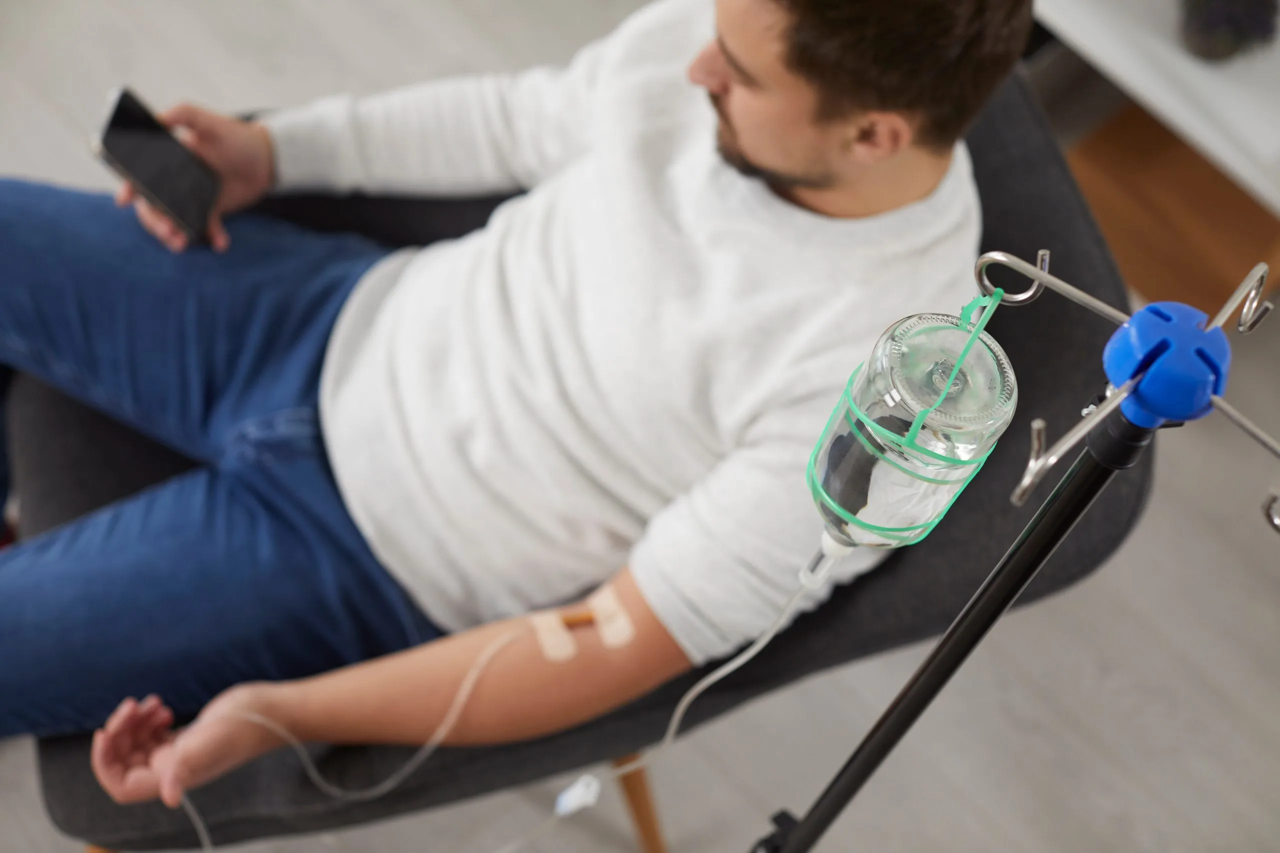 Patient receiving IV infusion with saline drip during medical treatment