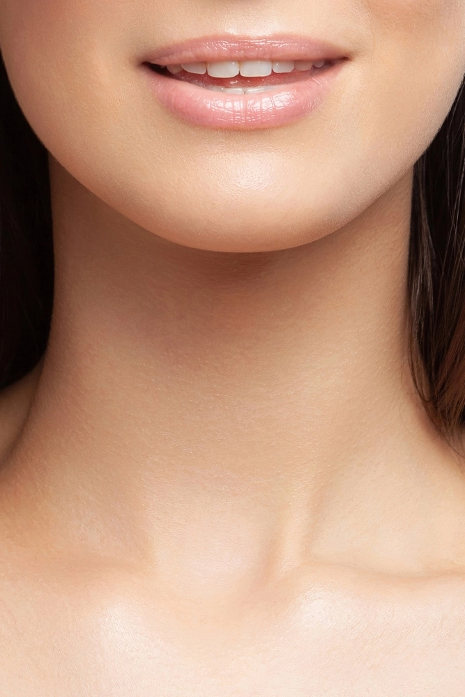 Close-up of a woman's smile showing straight, white teeth and natural lips