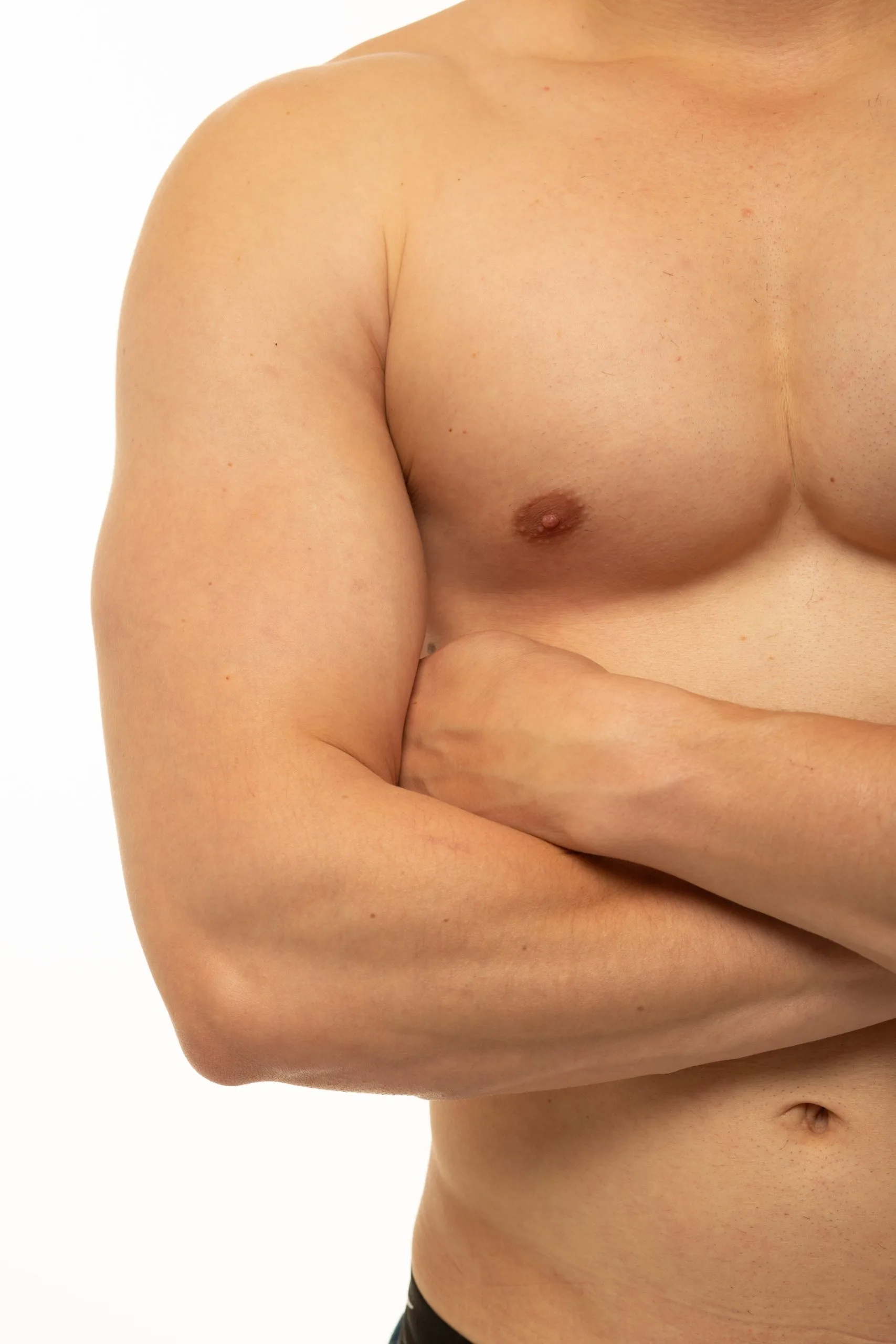 Shirtless man with arms crossed over chest, side torso view