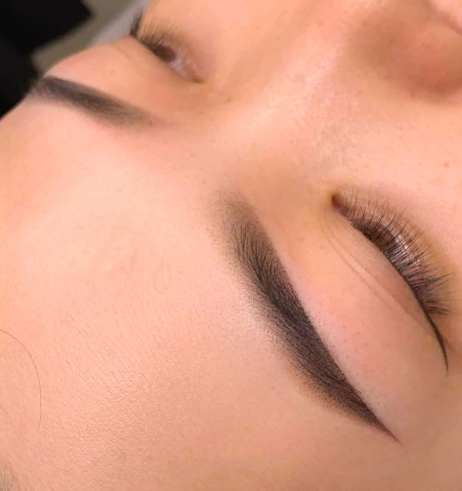 Close-up of eyelids with defined eyebrow and eye makeup