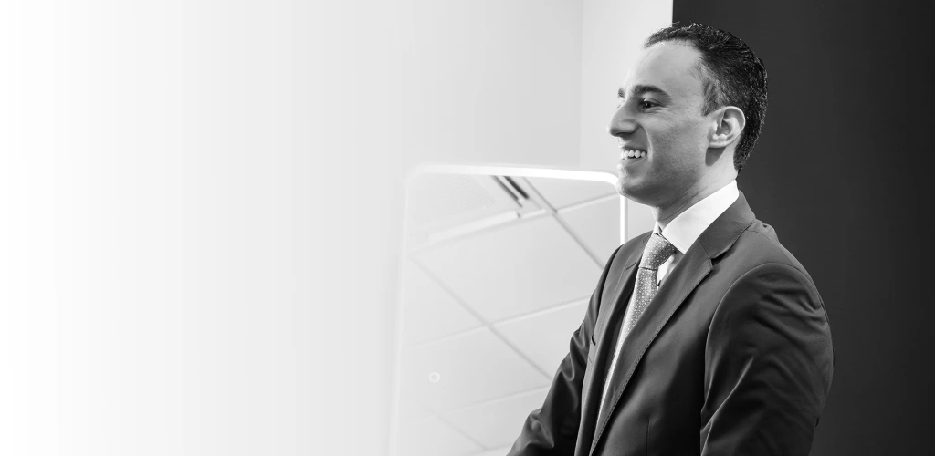 Dr. Daniel Bienstock in professional attire, smiling in profile in a modern office setting